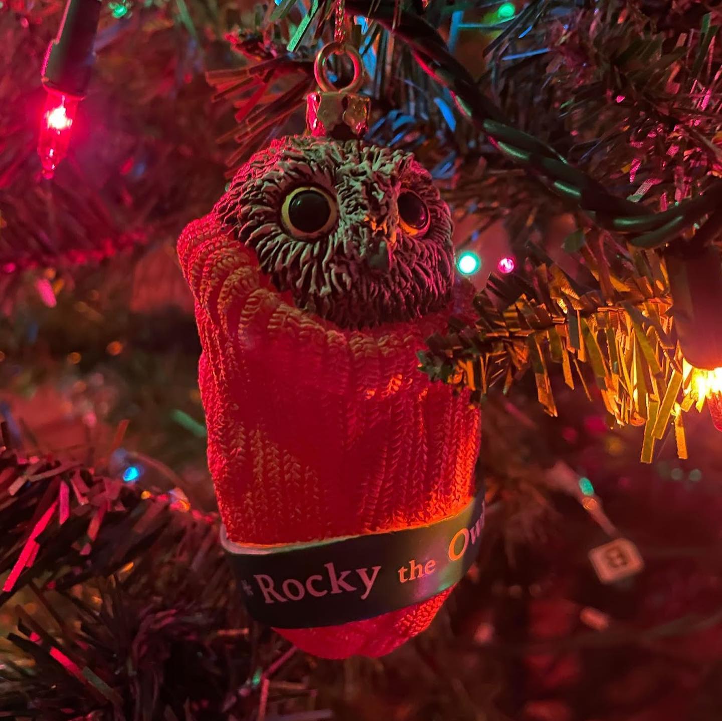 A Rocky figurine hanging from a xmas tree. The orange sleeve is shaped like a sock or stocking